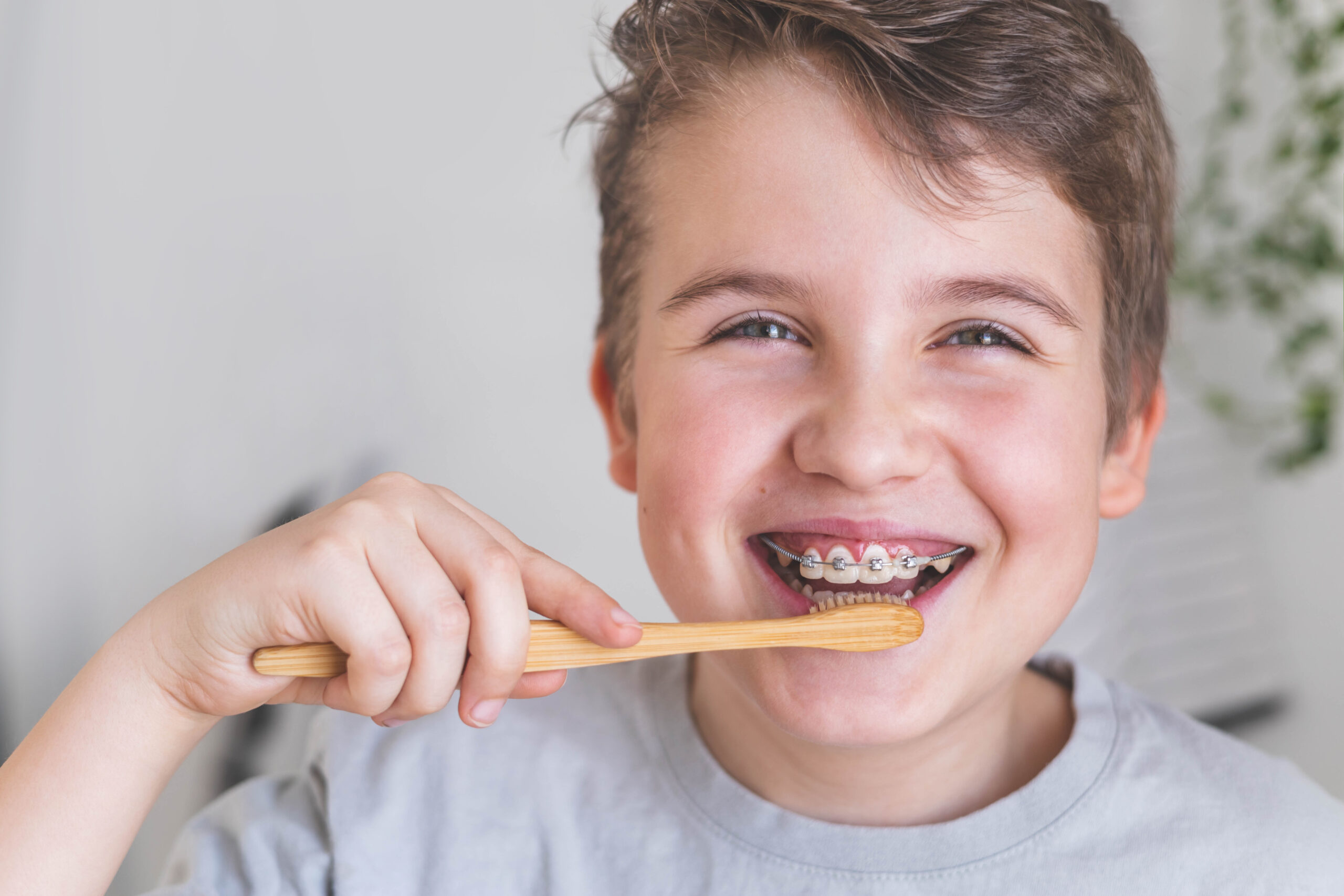 矯正中の男の子が笑顔で歯を磨いている