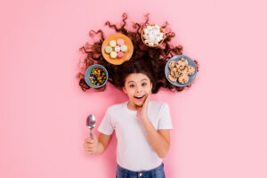 こどもがたくさんのお菓子を想像している