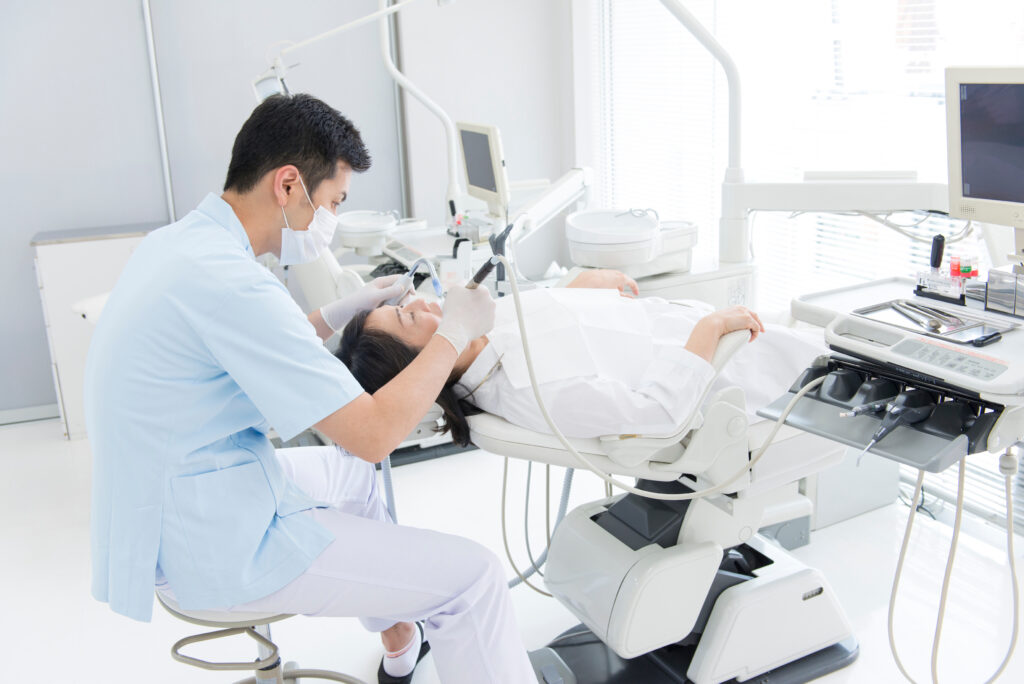 歯科医院で治療を受ける患者と治療する医師