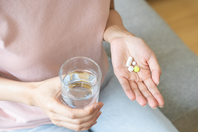 鎮痛剤を飲む女性