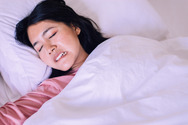 顎関節症の原因となる歯ぎしりをする女性