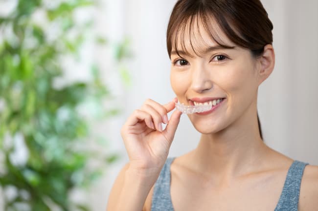 マウスピース矯正を装着しようとしている女性