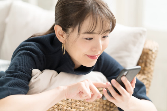 スマホで口コミを入力する女性