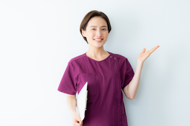 入れ歯の寿命が短くなる原因を伝える歯科医師の女性