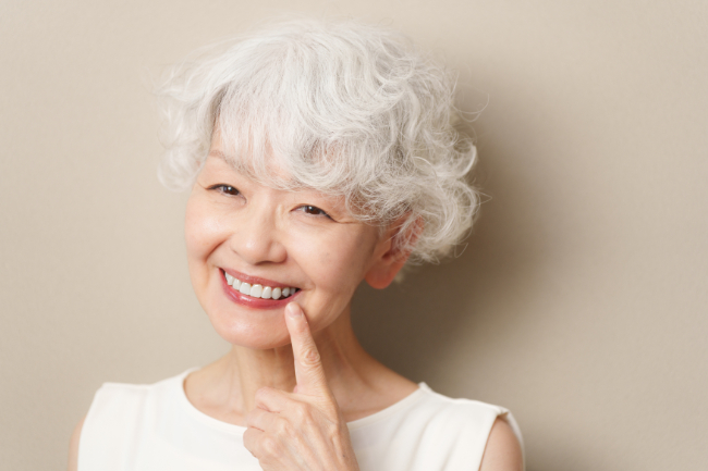 新しい入れ歯を入れて笑顔を見せる高齢女性