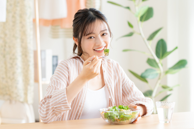 インプラント治療を無事に終え美味しく食事をいただく女性
