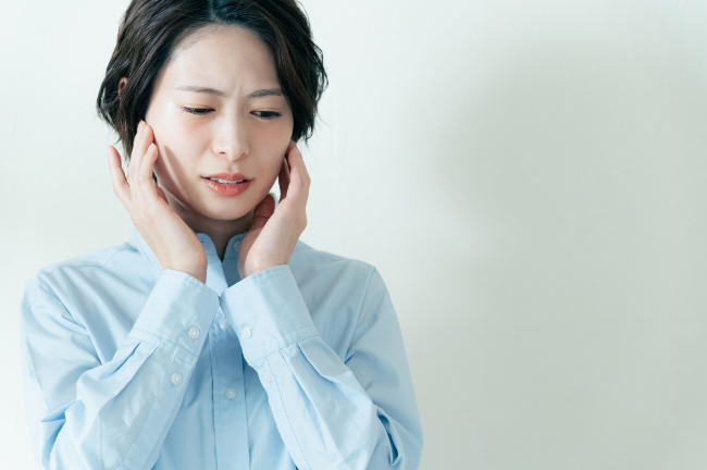 顎に痛みを感じる女性