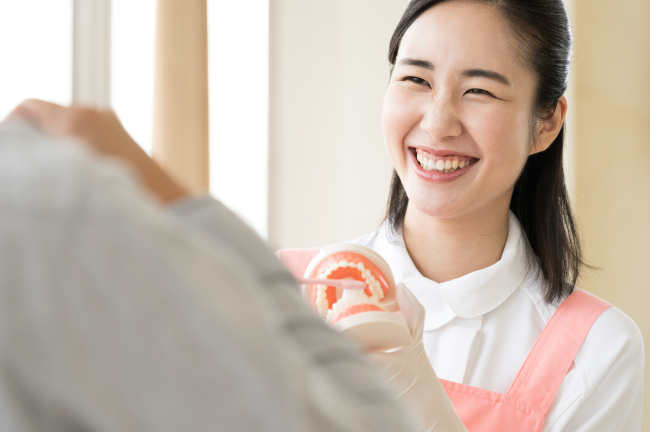 訪問歯科に訪れ笑顔で患者様のケアをする歯科衛生士