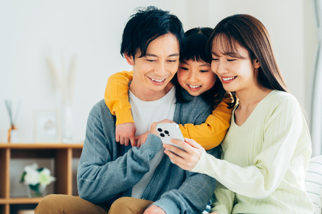 一緒にスマホを見る家族