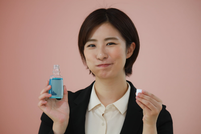 食後にマウスウォッシュでケアをするワイヤー矯正中の女性