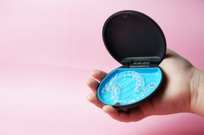 インビザラインのマウスピースを持った子どもの手のイメージ