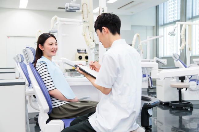 歯科医院で歯ぎしりの相談をする女性