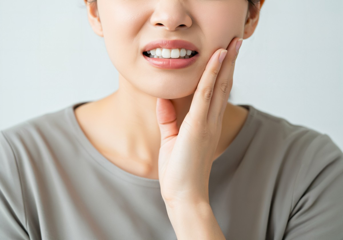 矯正治療で痛みを感じている女性